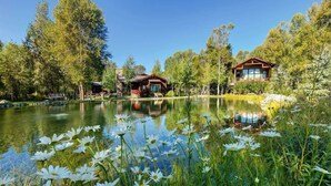 A lakeside cabin with a wooden deck and a view of the lake. - Abode at Three Bears, stunning wilderness estate (Jackson)