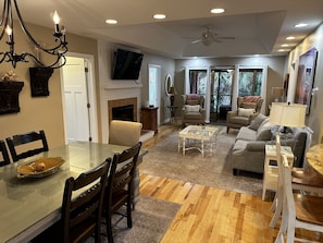 A spacious living room with a fireplace, a dining area with a glass table, and a comfortable seating arrangement.