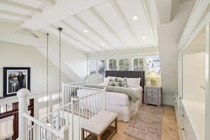 A bedroom with a bed, bedside table, and a window.