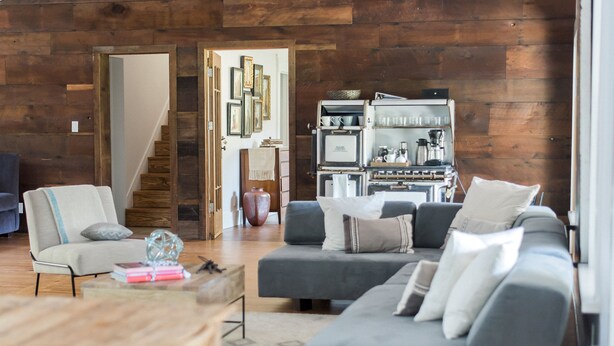A modern living room with a grey sofa, a wooden coffee table, and a staircase leading to another level. - Sabor Mexicano Vacation Retreat, (Guerneville)