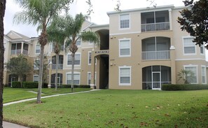 A multi-story apartment building with a beige facade, balconies, and a sign reading "2305 SILVER PALM DRIVE".