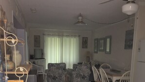 Ein Wohnzimmer mit Essbereich, Holzboden und Deckenventilator.