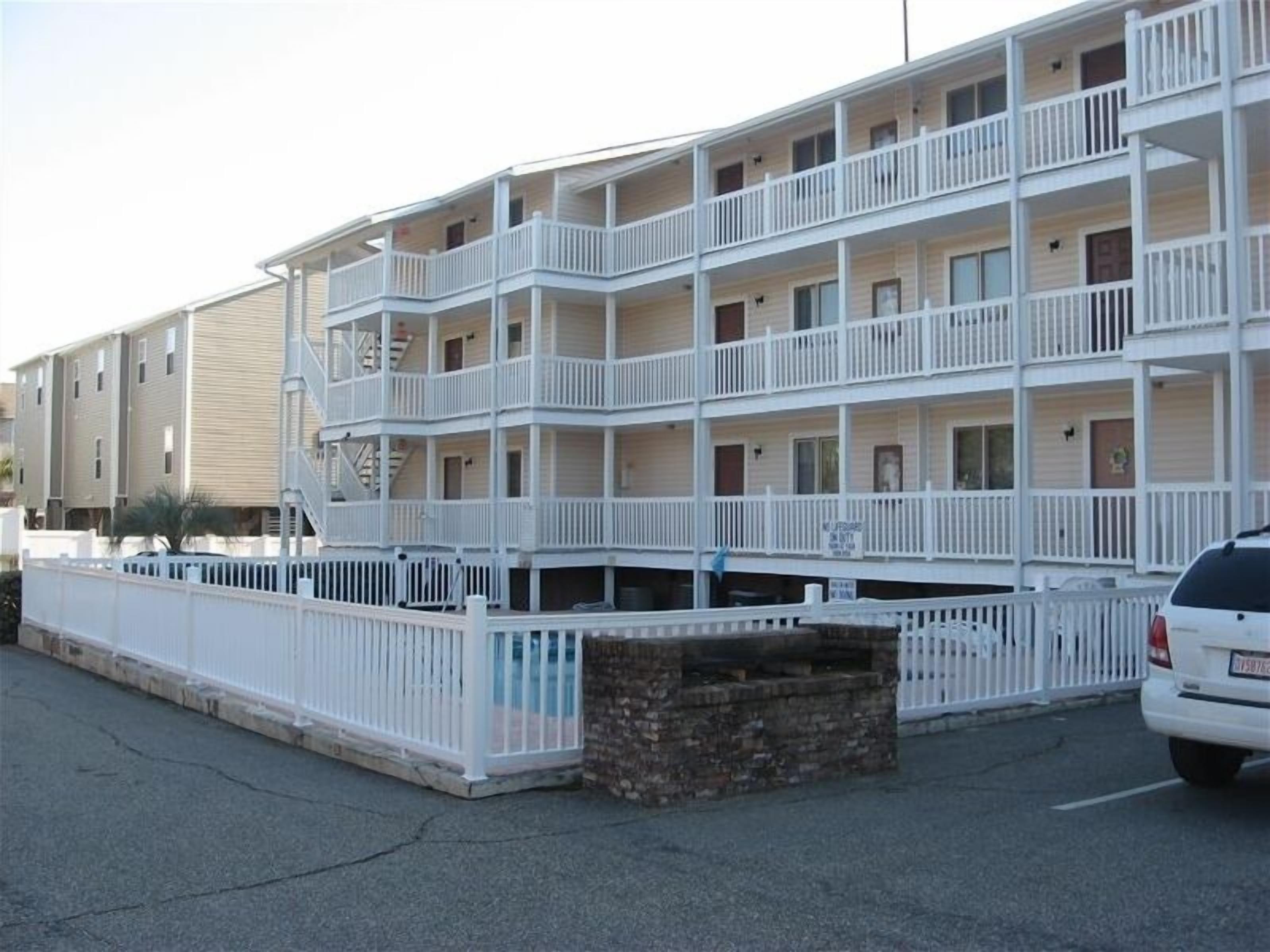 Un motel à plusieurs étages, doté de balcons et de rampes de couleur blanche.