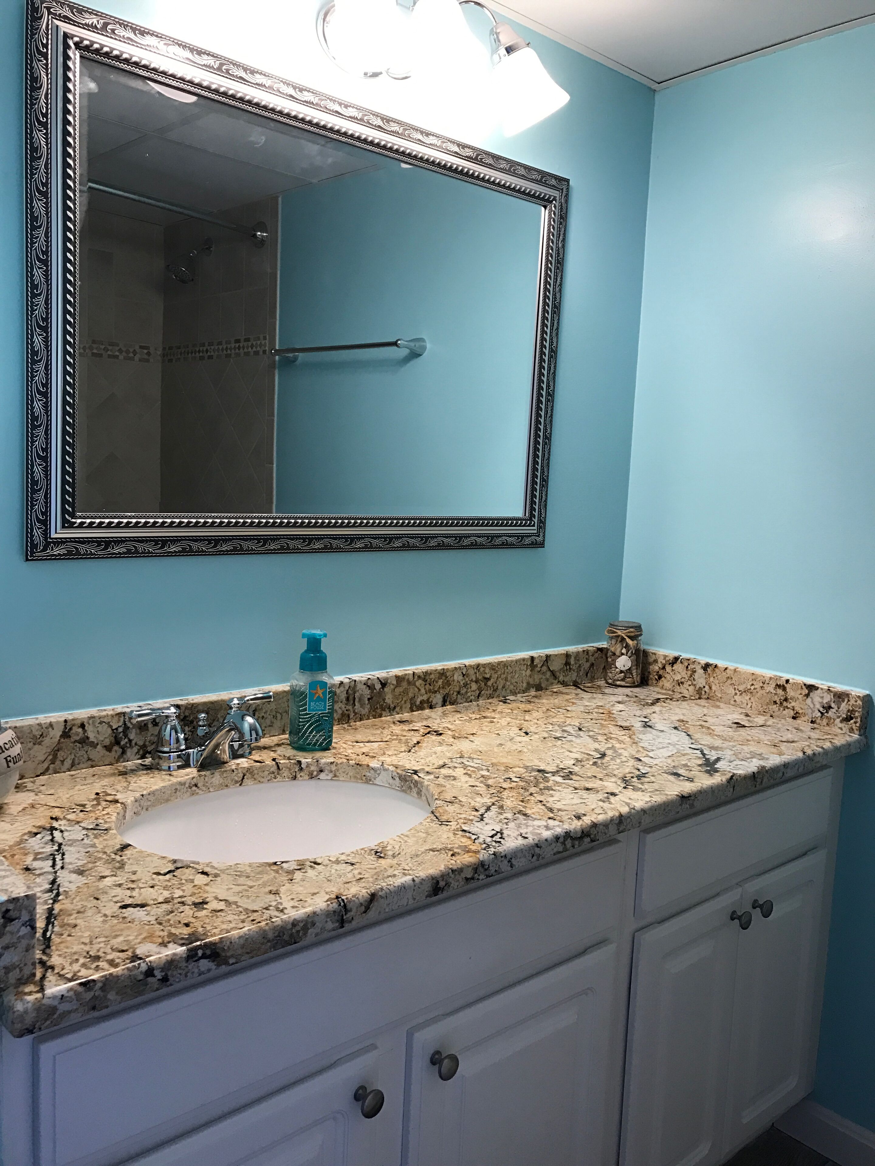 A bathroom with a sink, mirror, and vanity.