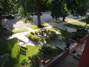 Stroll along the tree-lined street, surrounded by a well-maintained lawn and a charming garden with a birdbath.
