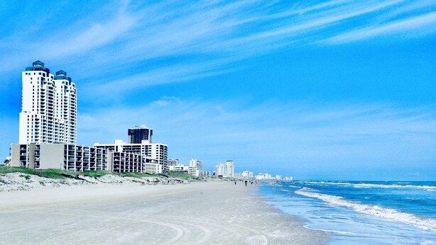 A beach with buildings in the background.