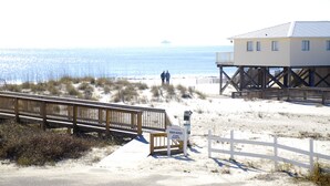A beach house with a wooden deck and a sign indicating beach access. - Best First Tier House - Located in beautiful Morgantown (Gulf Shores)