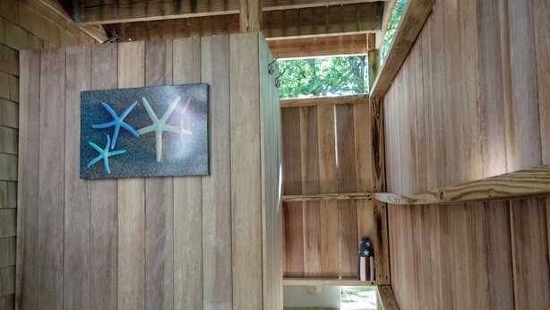 Een houten interieur met een kunstwerk in een lijst aan de muur.