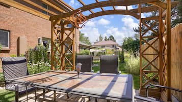 Relax in a serene outdoor space with a sturdy pergola, comfortable seating, and a metal table.