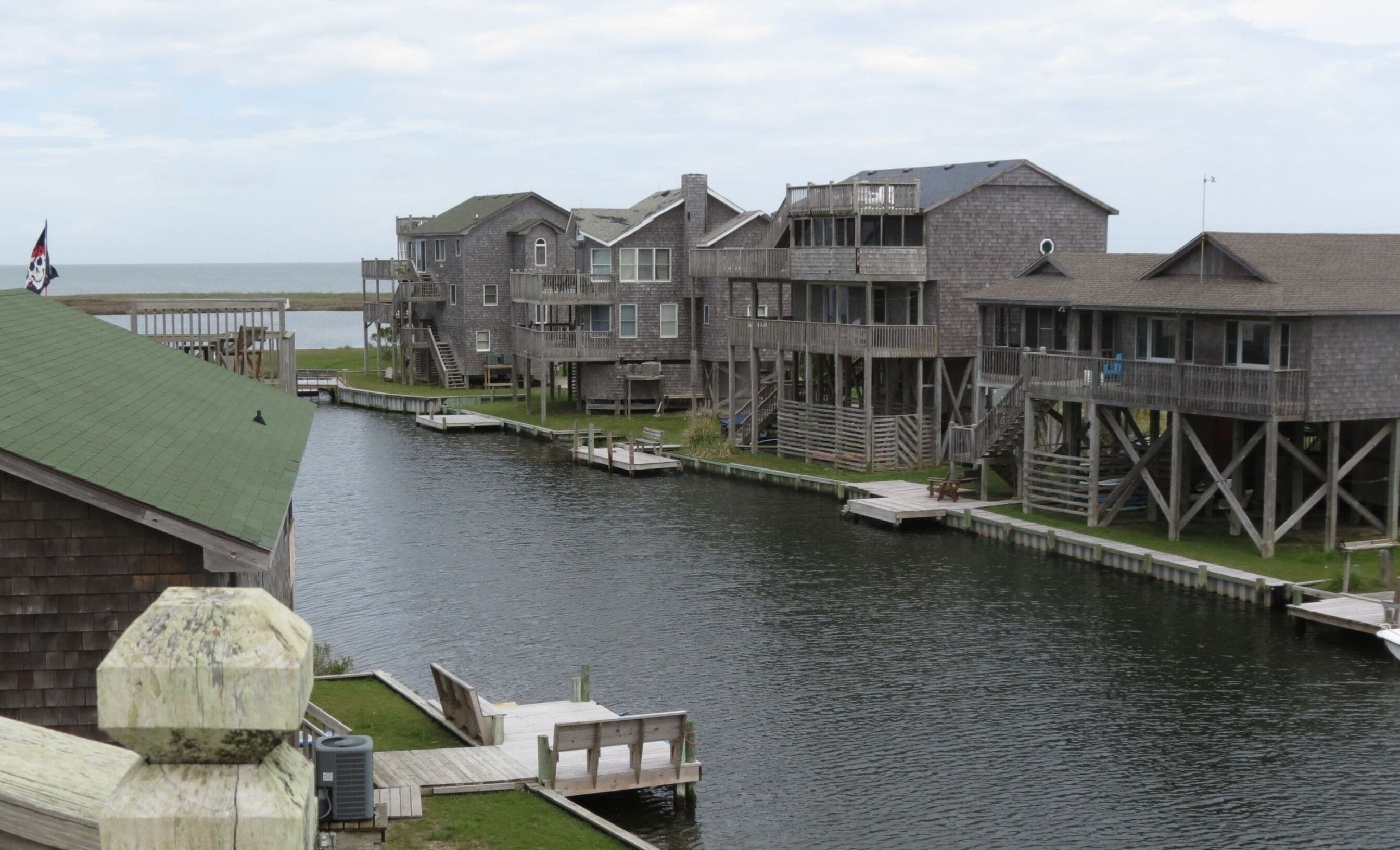 Una proprietà sul lungomare con diverse strutture in legno, tra cui un edificio principale e numerose terrazze rialzate, collegate da passerelle sull'acqua.