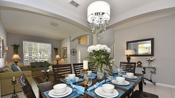 A dining area with a wooden table set for four, surrounded by chairs. - TOP REVIEWED HOME! Only 3 MILES to Disney, South Pool in Emerald Island Resort (Kissimmee)