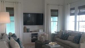 Ett modernt vardagsrum med en soffa, ett soffbord och en tv.