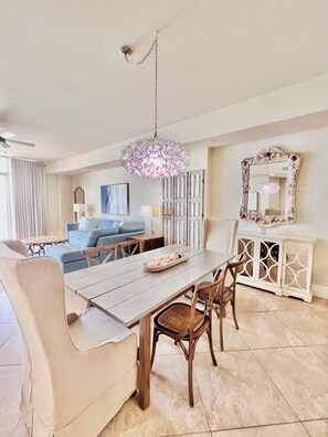 A dining area with a wooden table, chairs, and a decorative hanging light fixture.