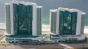 Two high-rise hotels with reflective glass facades, a beachfront, and a road in the foreground. - Spacious & Clean Oceanfront Paradise! Private Jacuzzi & New Grill! Great Reviews (Orange Beach)