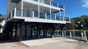 Un immeuble à plusieurs étages doté de balcons, d’un espace couvert et offrant une vue sur le front de mer.