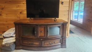 A wooden-paneled room with a large flat-screen TV on a dark wooden cabinet. - 2400sf Secluded Family Mountain House 16 Acres- 2 min to Jiminy Peak- near Lenox (Hancock)