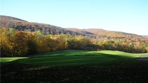 A golf course with a clear view of the surrounding forested hills. - 2400sf Secluded Family Mountain House 16 Acres- 2 min to Jiminy Peak- near Lenox (Hancock)