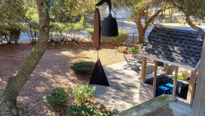 A wooden deck with a hanging star-shaped light fixture, a small gazebo, and a patio area with a table and chairs. - BLUE HAVEN-COROLLA-OBX (Corolla)