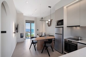 A modern kitchen with a central island, stainless steel appliances, and a view to the outside.