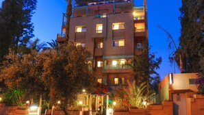 Un hotel de varios pisos con balcones y una entrada bien iluminada.