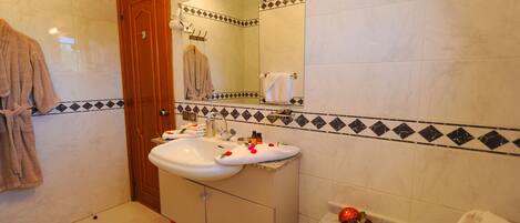 A bathroom with a sink, mirror, and two towels.