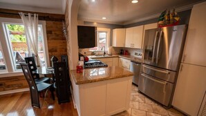 A modern kitchen with a central island, stainless steel appliances, and a dining area with chairs. - Walk everywhere; Beach 300 steps (Laguna Beach)