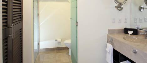 A modern bathroom with a glass shower enclosure, a toilet, a sink with a mirror, and a towel rack.