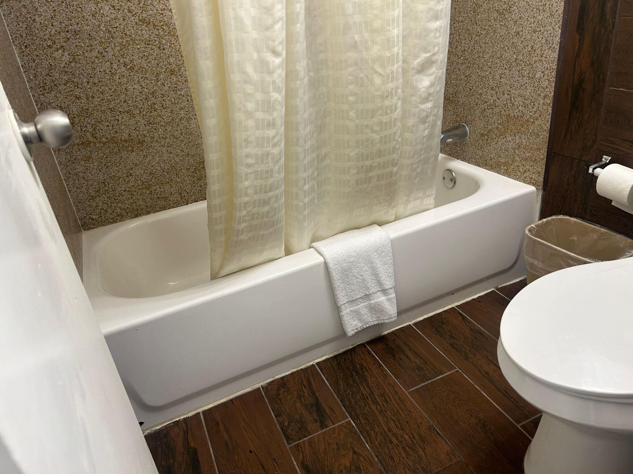 Un baño con bañera, inodoro y cortina de ducha.