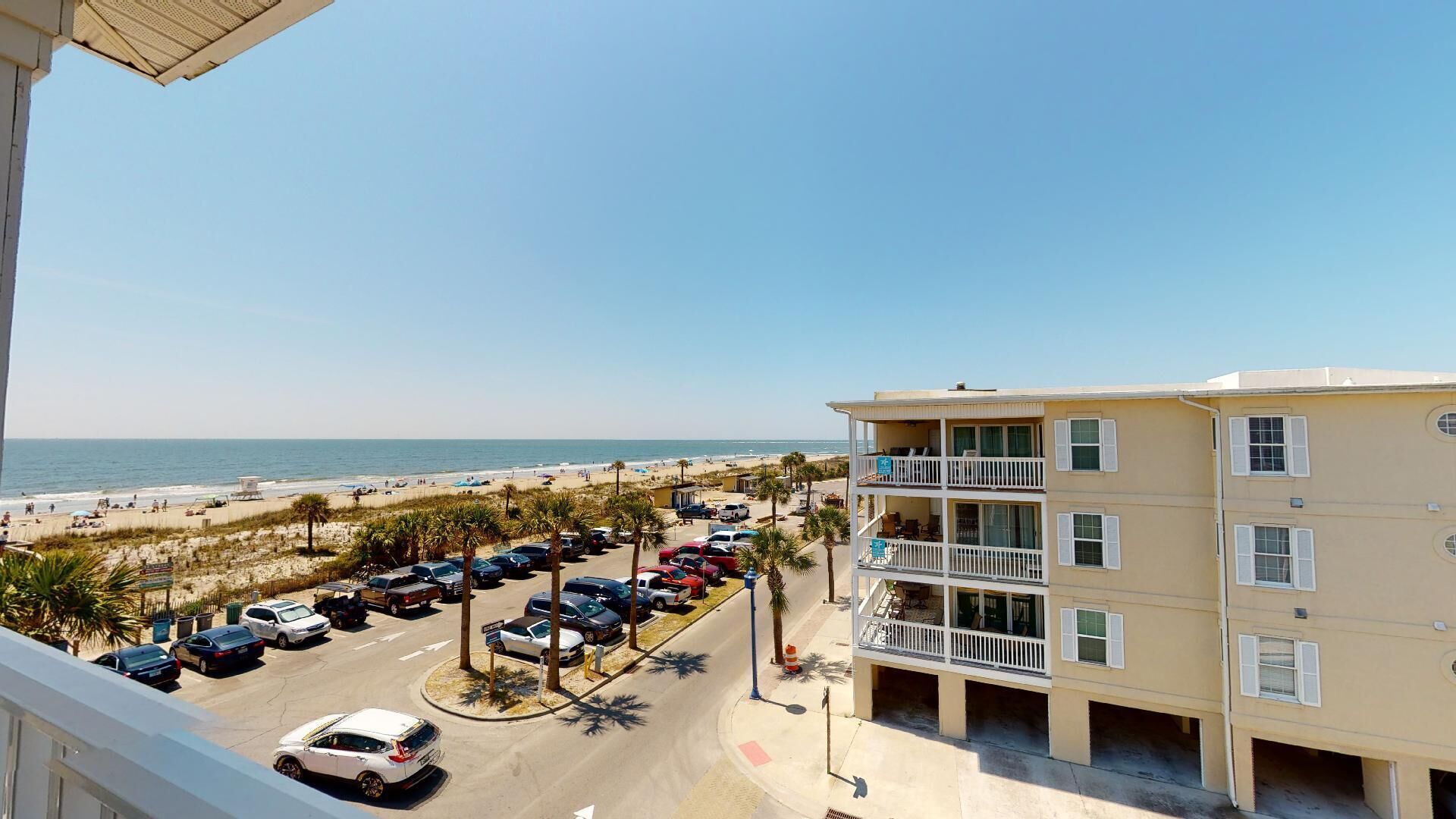 Un hôtel situé en bord de mer, doté de nombreux balcons, d’un parking et offrant une vue sur la plage.