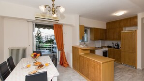 Eine moderne Küche mit Holzschränken, einer zentralen Kochinsel und einem Essbereich mit gedecktem Tisch für zwei Personen.