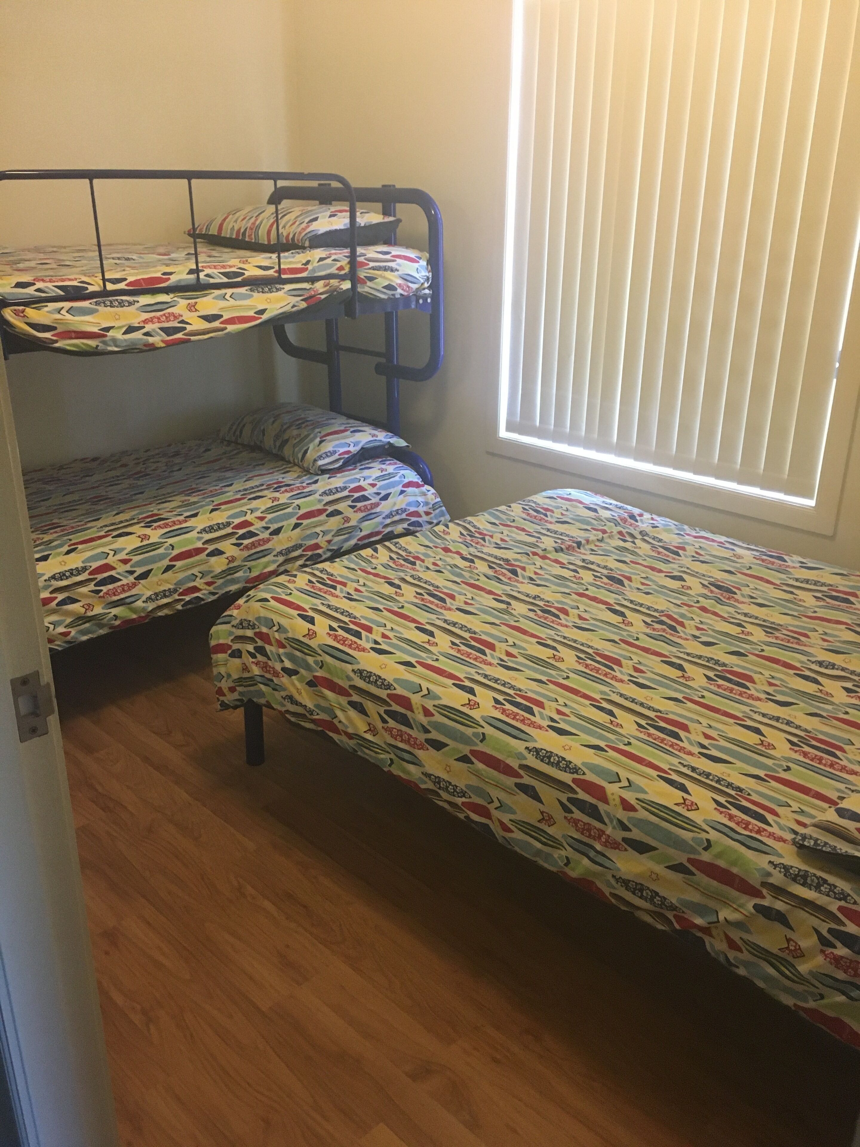 Un dormitorio con literas y una ventana con persianas.