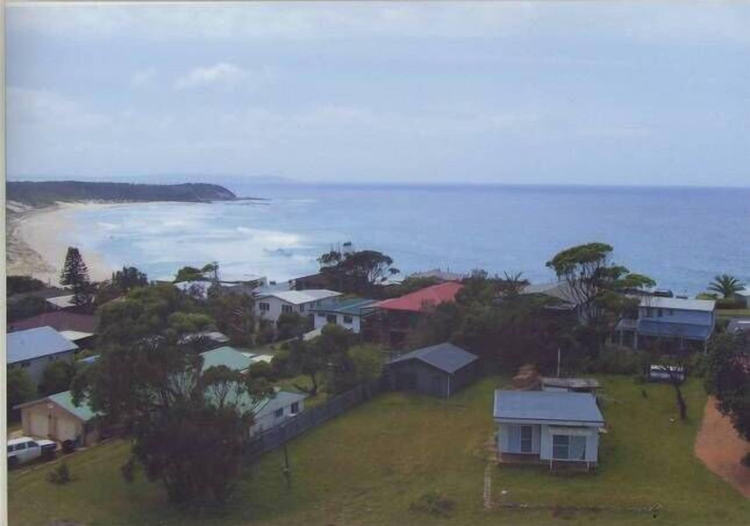 A coastal residential area with houses, a beach, and the ocean.