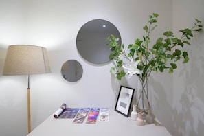 Relax in a serene space with a round mirror, lamp, and small table.