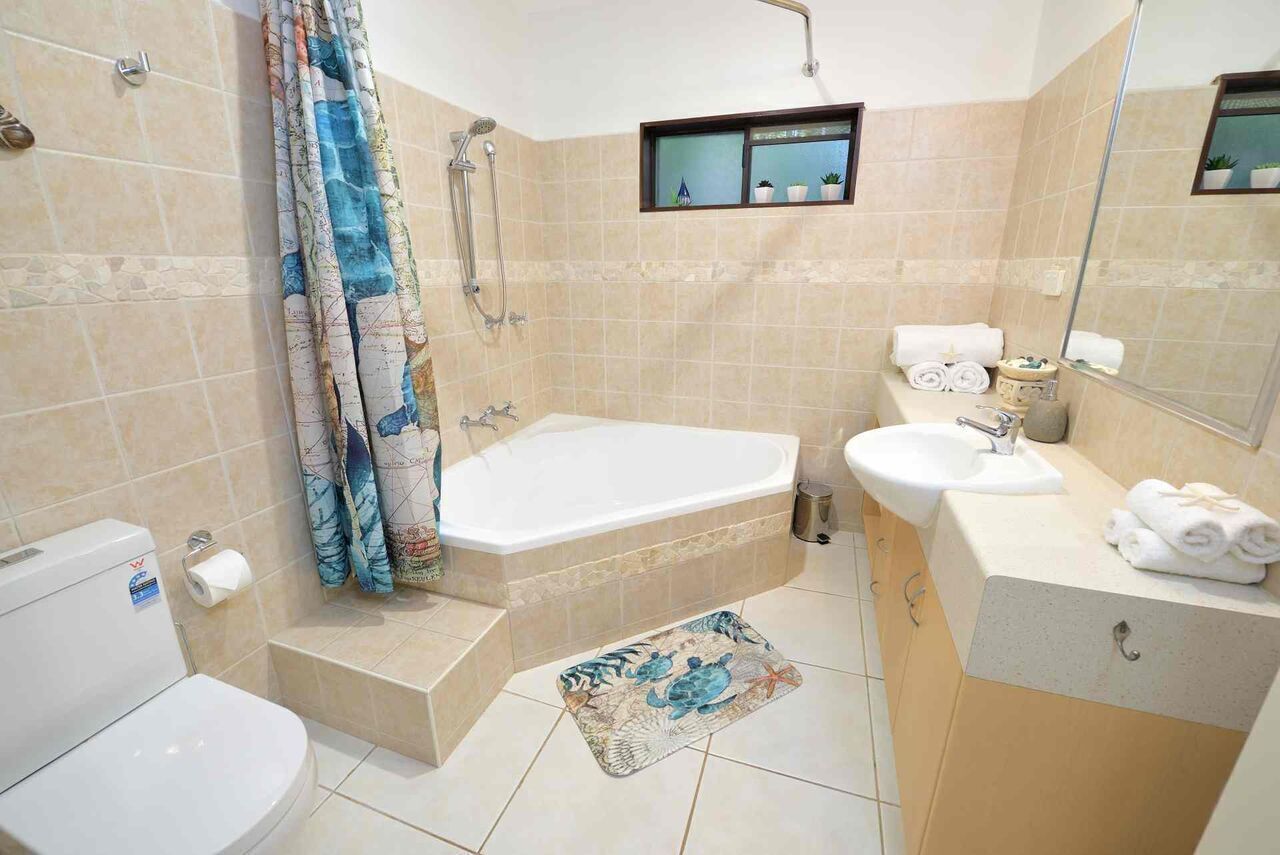 A bathroom with a bathtub, toilet, sink, and shower.