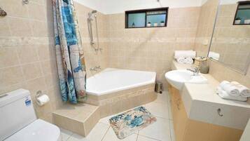 A bathroom with a bathtub, toilet, sink, and shower.