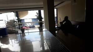 Una hall moderna con parete in vetro, una scala e un'area relax.