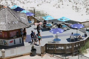 Un restaurant situé en bord de mer, avec une terrasse et des parasols.