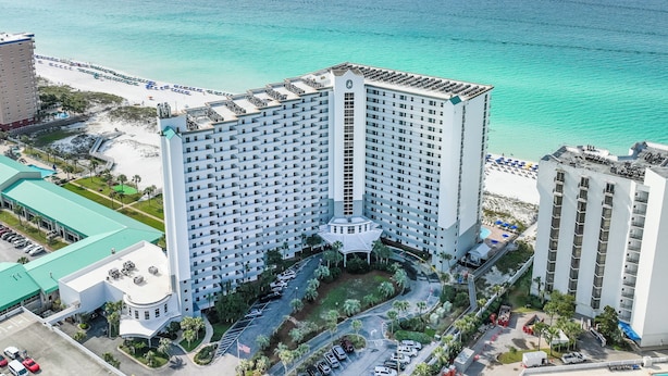 Un hôtel de grande hauteur doté d’une cour intérieure, entouré d’une plage et offrant une vue sur l’océan.