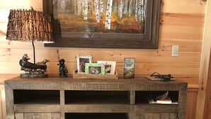 A wooden console table with a framed painting, decorative items, and a Father's Day card. - Paradox Lake - The Carriage House   (Severance)