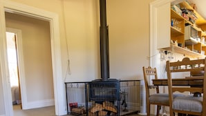 Una sala de estar acogedora con chimenea, una mesa de comedor y una estantería.