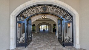 An arched hallway with a tiled floor and decorative metal railings.
