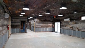 A hallway with wooden walls and ceiling, recessed lighting, and a fire extinguisher on the left. - The Mill House, year around Country Home & Historic Grist mill w/ 2 Kayaks (Posen)