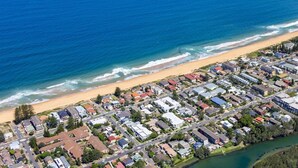 An aerial view of a coastal residential area with a beach, a river, and a bridge. - Apartment 1 - The Coachhouse (Sydney)