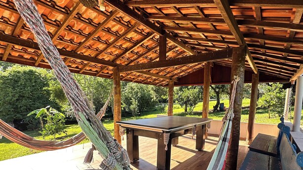 A hammock under a wooden pergola with a table and bench. - Property in Torrinha - near Brotas (Torrinha)