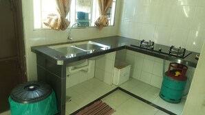 A compact kitchen with a sink, stove, and gas cylinder. - NEWLINA HOMESTAY, Nibong Tebal, Seberang Perai Selatan, Penang, Malaysia. (Nibong Tebal)