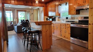 Une cuisine spacieuse, dotée de meubles en bois, d’un îlot central et d’une grande cuisinière.