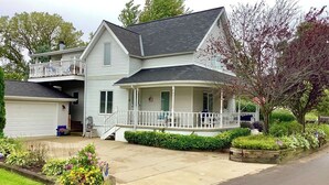 A two-story house with a porch, a garage, and a well-maintained garden.