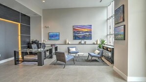 Un espace de bureau moderne comprenant un comptoir d’accueil, un coin salon et des œuvres d’art accrochées aux murs.