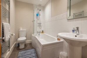 Un baño con inodoro, ducha, bañera y lavabo.