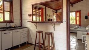 Una cocina con taburetes de madera, una barra y un espejo grande.